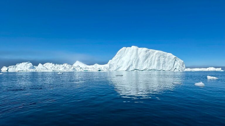Iceberg mirrored in calm water
