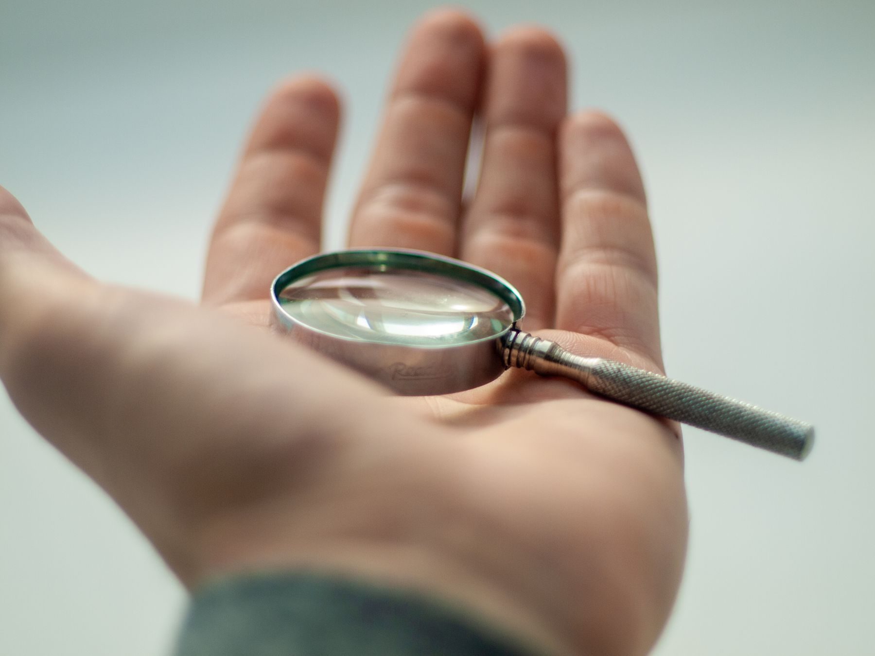 Magnifying glass lying on an open palm