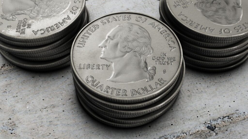 Stacks of U.S. quarter coins on a stone surface