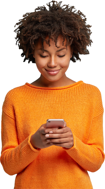 Woman in an orange sweater smiling at her phone