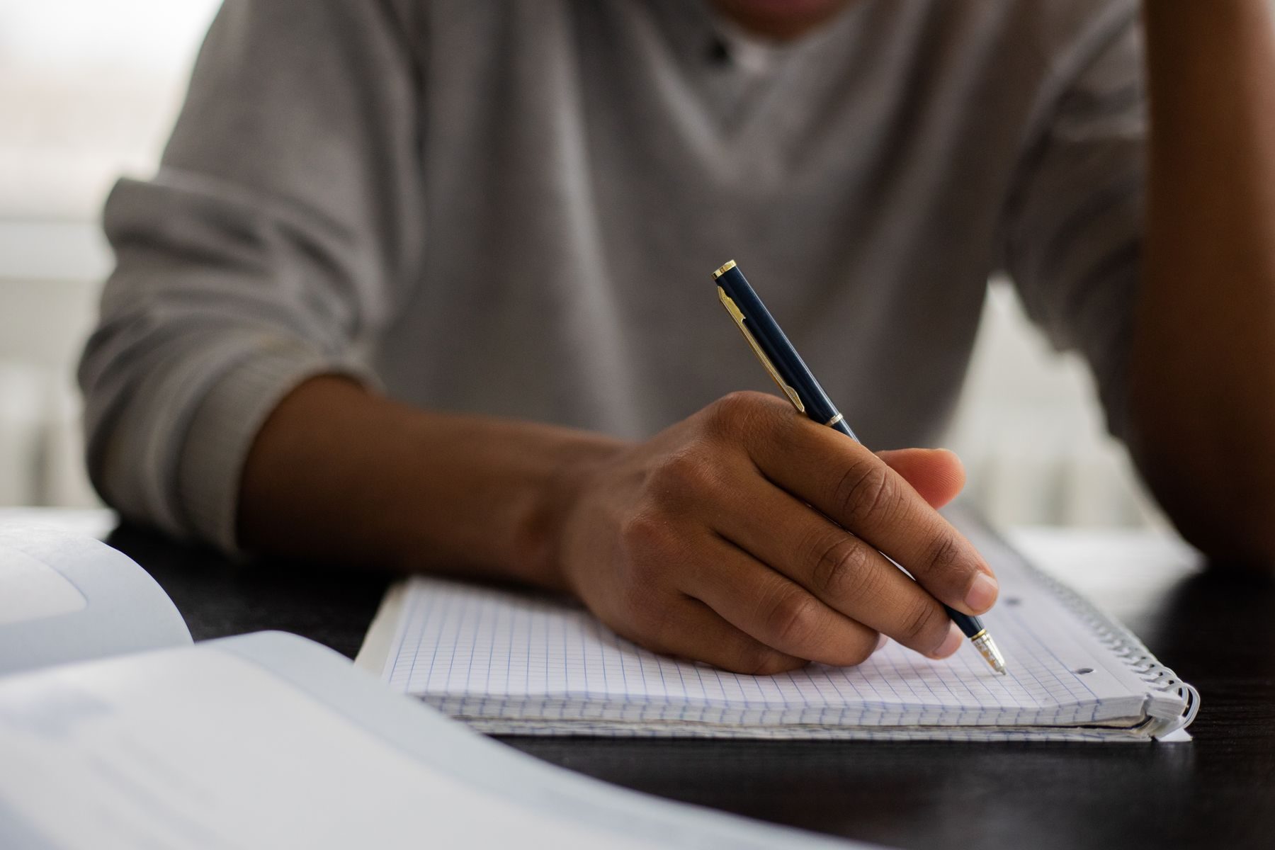 Hand writing notes in a workbook